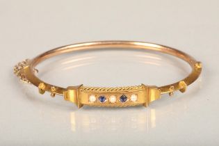 Victorian 9ct gold bangle set with sapphire and seed pearls, applied '9ct' lozenge to the reverse,