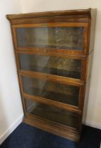 20th century oak Globe Wernicke style four tier bookcase, with up and over glazed doors on plinth