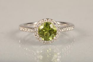 18ct white gold peridot and diamond ring, the 1.5ct brilliant cut peridot framed with a halo of