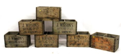 A set of seven early 20th century wooden bottle crates, emblazoned in black block print, 'J. Wilsons