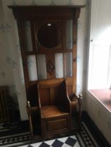 20th century oak hallstand having central circular mirror above settle style seat with hinged