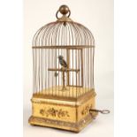 A 19th century mechanical singing bird in a cage, mounted on a gilded base, 55cm high.
