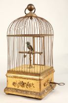 A 19th century mechanical singing bird in a cage, mounted on a gilded base, 55cm high.