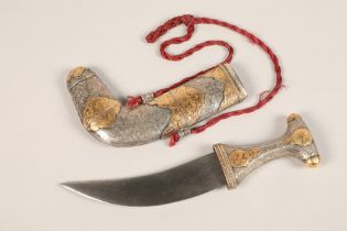 A Middle Eastern Omani white metal mounted Jambiya dagger, with gilt enrichments and engraved