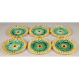 Seven piece Wedgwood majolica fruit set, with green lustre weave effect with yellow pierced border.