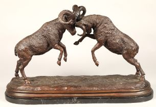 Twentieth century figure of two rams fighting, on marble base, signed T R, 75cm long,47 cm high.