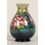 Moorcroft pottery vase of baluster form, green/blue ground in the clematis pattern, signed in blue