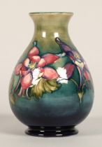 Moorcroft pottery vase of baluster form, green/blue ground in the clematis pattern, signed in blue