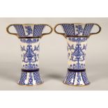 Pair of MacIntyre vases, flared form with looped handles, blue and white floral design, factory