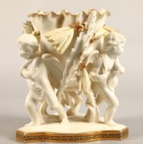 Moore Bros vase, three cupids supporting a bowl, 20cm high.