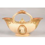 Royal Worcester double ended flower basket with oval relief mask panels in the classical style, 19cm