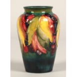 Moorcroft pottery vase of baluster form decorated in the leaf & berry pattern, 13cm high.