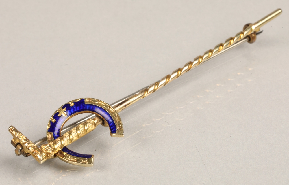 Ladies yellow metal brooch in the form of a walking stick with blue enamelled letter C, in a