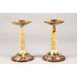 Pair of Doulton Lambeth aesthetic movement candlesticks in the liberty style, 23cm high (2)