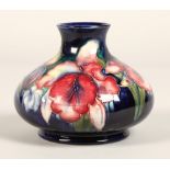 Moorcroft pottery vase, of squat form, blue ground in the iris pattern, impressed mark with blue