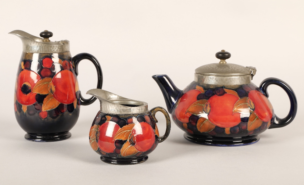 Moorcroft pottery Tudric pewter three piece tea service, pomegranate pattern designed by William