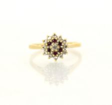 An untested ruby and diamond set cluster ring, the central round cut diamond within a surround of