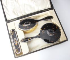 A cased George V silver and tortoiseshell mounted dressing table set, comprising hand held mirror,