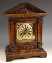 A German oak cased eight day mantel clock, by Junghans, early 20th century, the architectural case