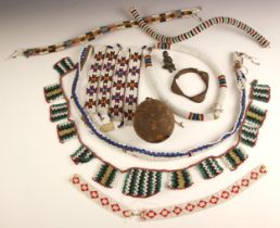 A collection of antique South African Zulu beadwork including belts and necklaces, a medicine gourd,
