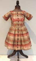 An 1840's fine wool tartan boys dress, the bodice lined with linen and the skirt with glazed cotton,