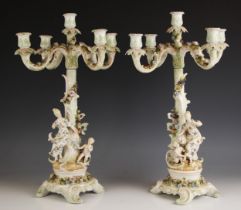 A pair of continental porcelain four branch figural candelabra with raised central sconce, late 19th