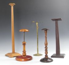 A collection of milliners stands, comprising; a Victorian adjustable turned wood and velvet example,