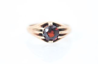 A 20th century style synthetic ruby gypsy set ring, the round cut red stone within claw set