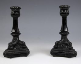 A pair of Westmoreland black milk glass candlesticks, 20th century, the trefoil base modelled as