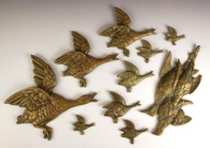 A set of three brass graduated birds, each modelled flying, 26cm high to 17cm high, and a brass