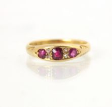 An Edwardian untested ruby and diamond ring, the central cushion cut red stone with a smaller