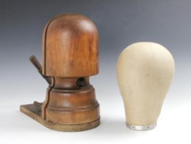 An Edwardian turned mahogany milliners hat block or stretcher, circa 1910, with a linen covered