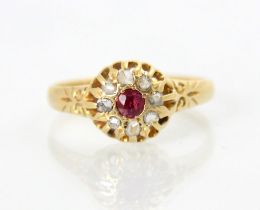 An early 20th century 18ct diamond and untested ruby cluster ring, the round cut red stone within