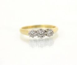 An 18ct yellow gold three stone diamond ring, the central round cut diamond with smaller diamond