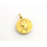 A yellow metal pendant or locket, the circular locket with Art Nouveau style decoration and
