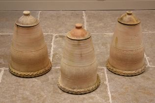 A trio of terracotta rhubarb forcers, each of bell form with pie crust rim and removable covers,