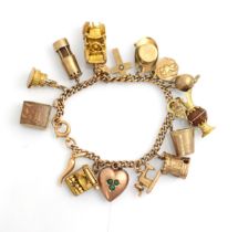 A yellow metal charm bracelet, the curb link bracelet suspending sixteen charms including