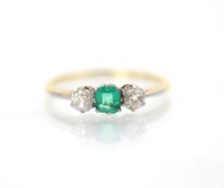 An early 20th century emerald and diamond three stone ring, the central square cut emerald with an