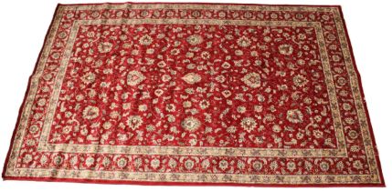 A rich red ground full pile Kashmir carpet, all over trailing foliate design, enclosed by twin ivory