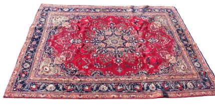 A large multi coloured field vintage Persian Mashad carpet with traditional floral medallion upon