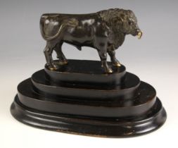 A bronze model of a bull, 20th century, modelled standing, with gilt highlights, raised upon a