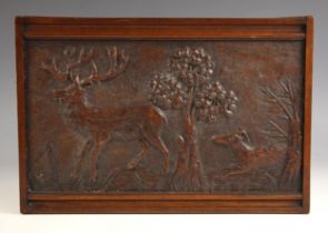 A Folk Art relief carved walnut hunting scene panel, 19th century, depicting a stag and hound within