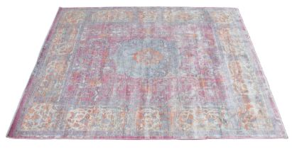 A modern rug, the foliate pattern in bleached shades of red, blue and gold, 298cm x 247cm