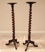 A pair of Victorian mahogany torcheres, each with a moulded circular tray top upon a barley twist