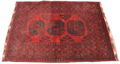 A washed red Afghan double knot rug, full pile Bokhara, the three octagonal medallions upon a red