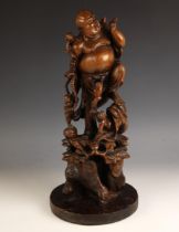 A large Chinese carved wood figure of a laughing Buddha, late 19th century, modelled standing upon a