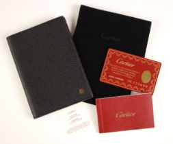 A Cartier black leather passport case, maroon interior with red stitching, with applied Cartier