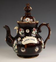 A Measham type barge ware teapot and cover, 20th century, of typical form, treacle glazed, applied