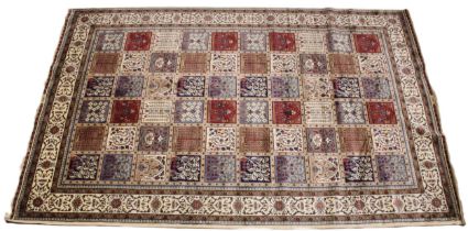 An ivory ground Kashmir carpet, traditional Persian panel design, in ivory, gold, red and blue