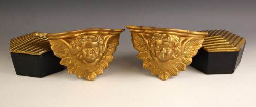 A pair of gilt wall brackets, modelled as a cherub amongst foliage, 23cm wide, and two boxes and